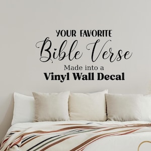 以下が含まれることがあります： YOUR FAVORITE Bible Verse Made into a Vinyl Wall Decalというテキストが書かれた黒いビニール製のウォールステッカー。太字のサンセリフ体とエレガントな筆記体を組み合わせたフォントで、Bibleのiの文字の上に小さなハートのアイコンがデザインされています。