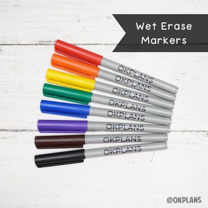 May include: A set of eight wet erase markers in various colors, including red, orange, yellow, green, blue, purple, brown, and black. Each marker has the word "OKPLANS" printed on the barrel.