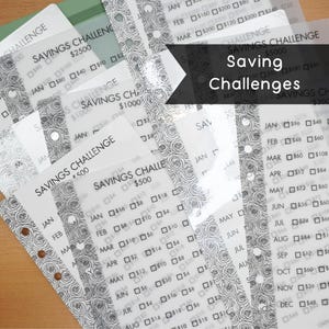 May include: A set of clear plastic sheets with a floral pattern and a grid of boxes for tracking savings goals. Each sheet has a different savings challenge amount, such as $500, $1000, $2500, and $5000. The sheets are labeled with months of the year, January through December, and have boxes for each month to track savings progress.