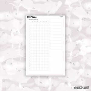 May include: A printable planner page with a grid for tracking a year in pixels. The page is labeled "Year in Pixels" and includes the months of the year. The page also has a section for notes.
