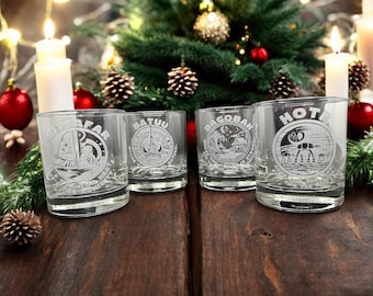 May include: Four clear glass tumblers with etched designs from the Star Wars universe. The designs include "Tatooine", "Dagobah", "Batuu", and "Hoth".