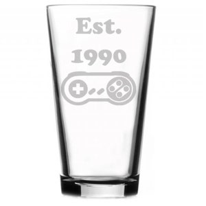 May include: A clear glass pint glass with the text "Est. 1990" and a retro video game controller etched on the front.