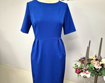 May include: A royal blue knee-length dress with a round neckline and short sleeves. The dress has a fitted bodice and a slightly flared skirt. The dress is on a mannequin.
