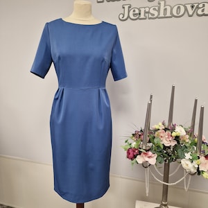Women's sheath dress, light blue, with short sleeves, pockets, back slit.  Boat neckline.  Zipper on the back. Knee length