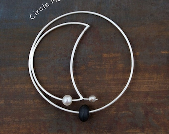 Circle Moon_ enkele zilveren statementoorbel met parels en strandkiezel _ damesoorbellen_van Ariadni Kypri_YDOR-collectie