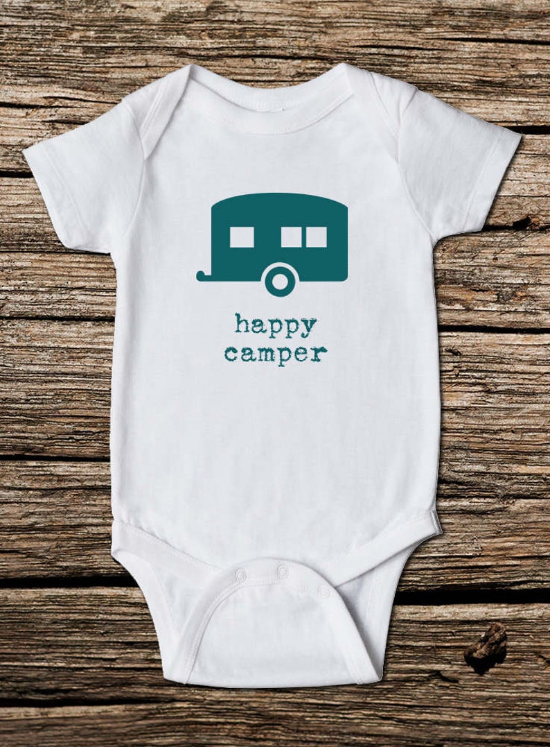 May include: White baby onesie with a teal camper graphic and the words "happy camper" in teal. The onesie is made of soft material and has short sleeves. The design is centered on the front.