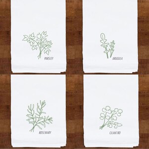 May include: Four white kitchen towels with green botanical illustrations. Each towel features a different herb: parsley, arugula, rosemary, and cilantro. The herb names are printed below each illustration.