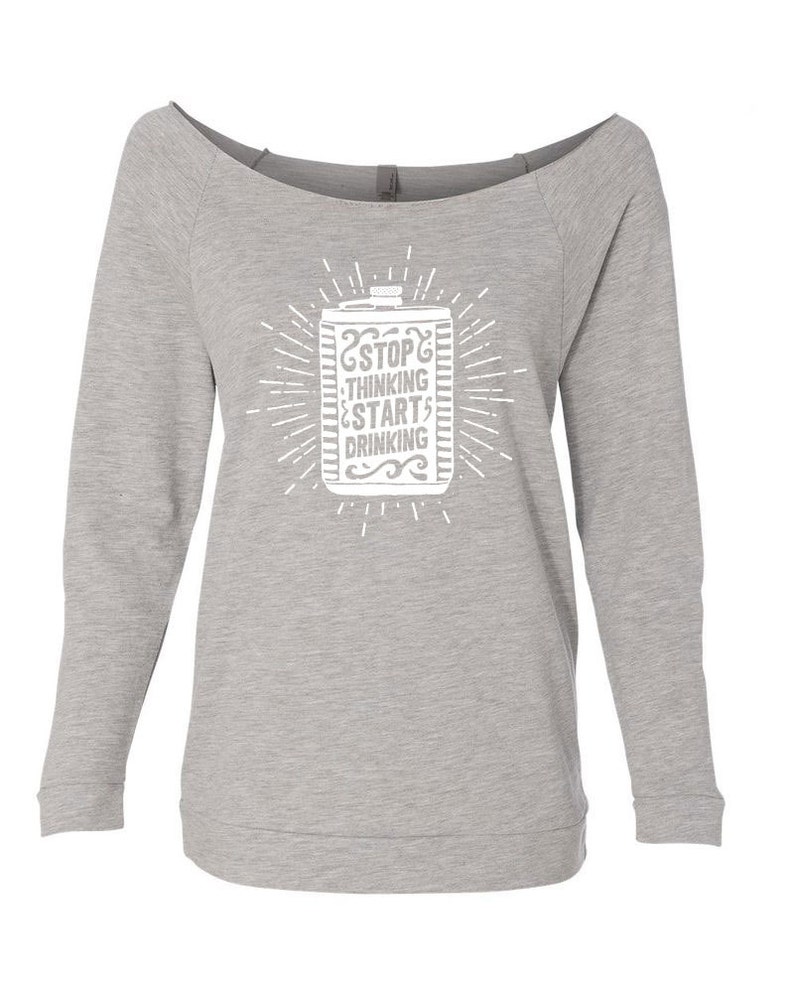 May include: A light gray off-the-shoulder sweatshirt with long sleeves. The front features a white graphic of a beverage container with the text "STOP THINKING START DRINKING" in a stylized font, surrounded by radiating lines.