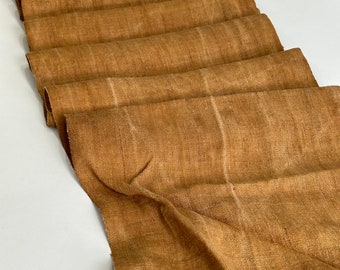 Peut inclure: Un chemin de table en tissu marron plié avec un tissage texturé. Le chemin de table est fait d'une fibre naturelle et a une surface légèrement inégale. Le tissu est plié en une série de plis, créant un effet superposé. Idéal pour la décoration intérieure.