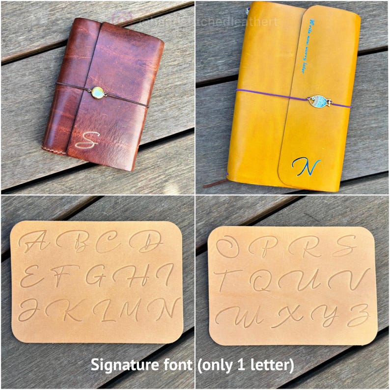 May include: A dark brown leather journal with a circular charm and the letter S, a yellow leather journal with a fish charm and the letter N, and two tan leather sheets displaying an alphabet in a cursive font for personalization options.