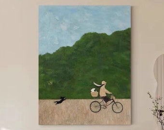 May include: A painting of a person riding a bicycle with a dog running beside them. The person is wearing a hat and a scarf. The background is a green hill with a blue sky.