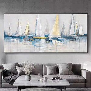 May include: Abstract painting of sailboats on a blue and white water background. The sailboats are white with gold accents. The painting is framed in a black frame.