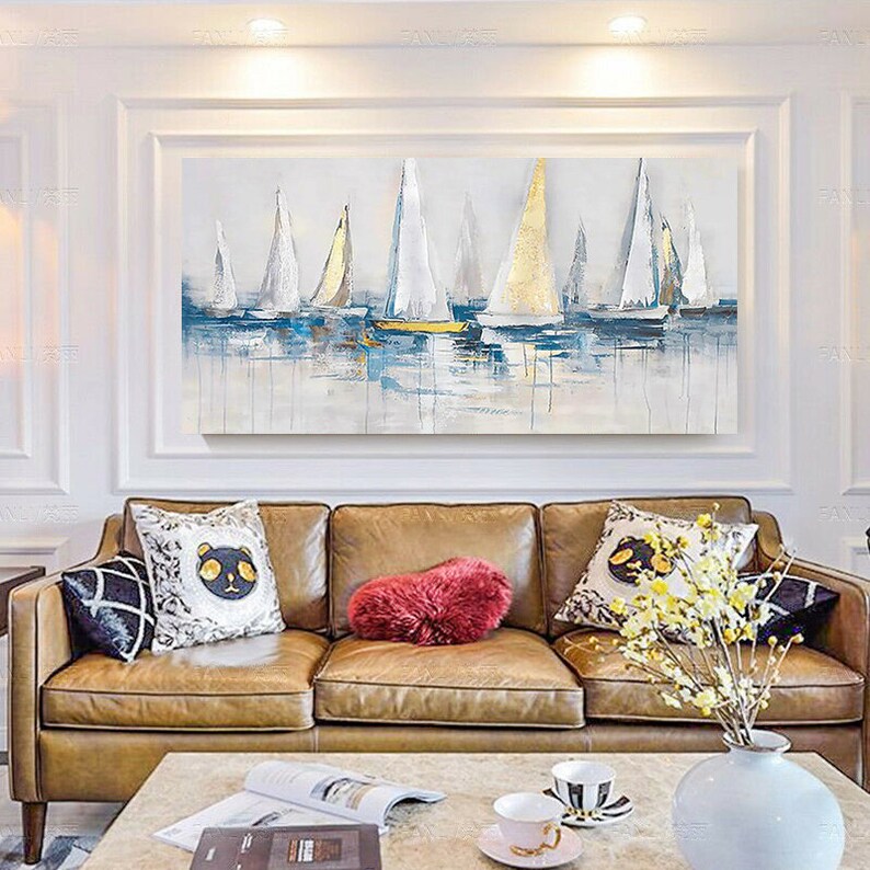 May include: A painting of sailboats on a body of water. The sailboats are white with gold accents. The water is blue and green. The painting is framed in a gold frame.