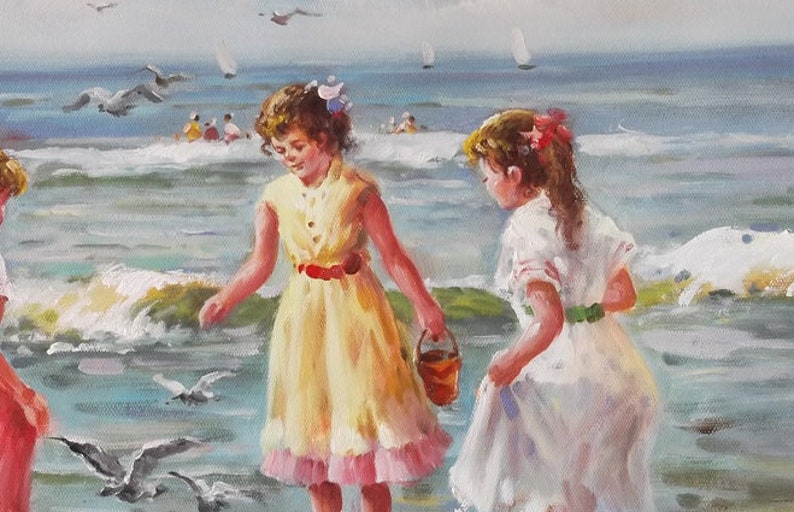 May include: Two girls in white and yellow dresses play on a beach with blue water and white waves. One girl holds a red bucket. Seagulls fly overhead.