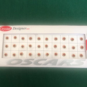 May include: A sheet of red and gold round stickers with the text "Crystal Designer Bindi" at the top. The stickers are arranged in a grid pattern.