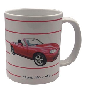 May include: White ceramic mug featuring a red Mazda MX-5 Mk2 convertible car printed on it. The mug has red stripes around the body and the text "Mazda MX-5 Mk2" is printed on the bottom.