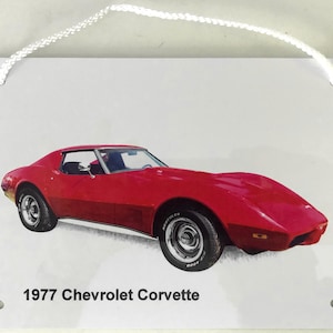 May include: A red 1977 Chevrolet Corvette against a white background. The car has black trim and black wheels.