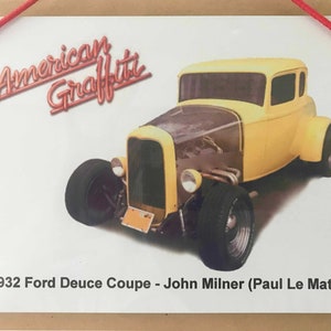 Könnte beinhalten: Ein gelber 1932 Ford Deuce Coupe, ein klassisches Hot-Rod-Auto, mit den Worten "American Graffiti" in roten Buchstaben darüber. Die Bildunterschrift unter dem Auto lautet "1932 Ford Deuce Coupe - John Milner (Paul Le Mat)".