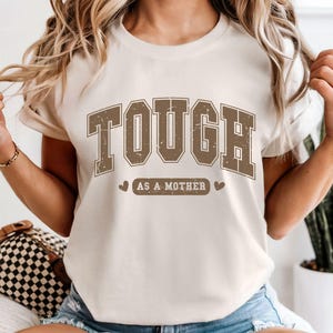 Camiseta "Tough as a Mother" com cores confortáveis, camiseta estampada "Mãe Forte", camiseta "Mãe Empoderadora", lavagem vintage suave, caimento unissex, camiseta para maternidade