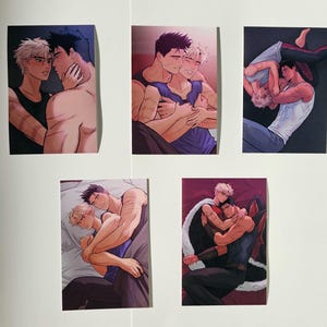 Puede incluir: Cinco impresiones artísticas que presentan ilustraciones de dos figuras masculinas en varios abrazos. Las ilustraciones tienen una paleta de colores suaves, con un enfoque en las expresiones e interacciones de las figuras. Las impresiones se muestran sobre una superficie blanca.