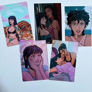 以下が含まれることがあります： 女性のイラストが描かれた5枚のアートプリントのコレクション。ポートレートや親密な瞬間など、さまざまなシーンが描かれています。青、ピンク、オレンジの色使いで、詳細な線画と様式化された人物が特徴です。