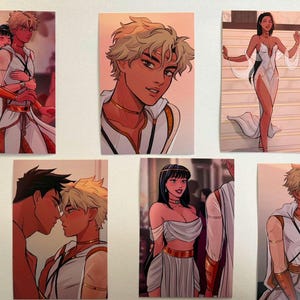 May include: A collection of six art prints featuring illustrations of characters in white and gold attire. The prints depict various scenes, including couples embracing and individuals in elegant poses. The artwork has a stylized, anime-inspired aesthetic.