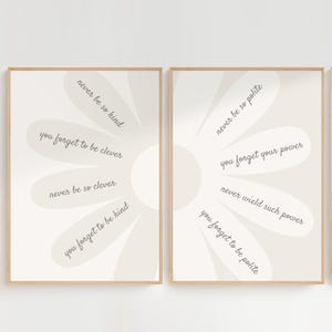 Puede incluir: Dos impresiones artísticas enmarcadas con diseños en forma de margarita y citas inspiradoras en una paleta de colores suaves y neutros. Las citas incluyen frases como "Never be so kind" y "You forget to be clever."
