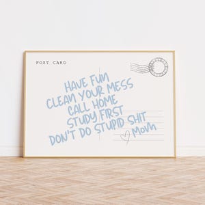 Może przedstawiać: Oprawiona pocztówka z jasnoniebieskim tłem i złotą ramą. Tekst "HAVE FUN, CLEAN YOUR MESS, CALL HOME, STUDY FIRST, DON'T DO STUPID SHIT, Mom" jest napisany na jasnoniebiesko. Słowa są w stylu ręcznym.