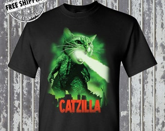 Może przedstawiać: Czarny T-shirt z zielonym nadrukiem potwora catzilla i napisem "CATZILLA" w kolorze czerwonym.