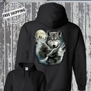 Peut inclure: Sweat-shirt à capuche noir avec un imprimé graphique de trois loups hurlant à la lune. Les loups sont dans un décor de forêt sombre avec une pleine lune en arrière-plan.
