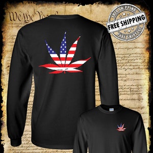May include: Black long-sleeve t-shirt with a marijuana leaf design featuring the American flag. The shirt has a crew neck and long sleeves. The design is centered on the back of the shirt. The shirt is available in a variety of sizes.