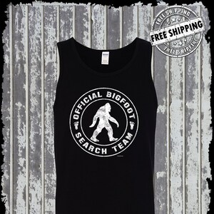 May include: Black tank top with a white graphic of a Bigfoot silhouette inside a circle with the text "Official Bigfoot Search Team".