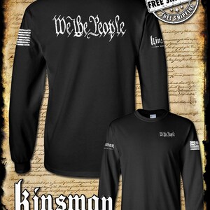 May include: Black long-sleeved shirt with the text "We the People" printed on the back. The shirt has an American flag design on the left sleeve and the text "Kinsman Trading Co. LLC" on the bottom.