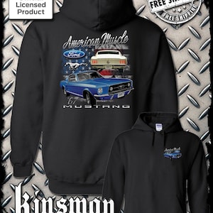 May include: Black hooded sweatshirt with a graphic of a blue 1967 Ford Mustang with the text "American Muscle" and "67 Mustang" on the back. The front of the sweatshirt has a smaller graphic of a blue Mustang with the text "American Muscle".