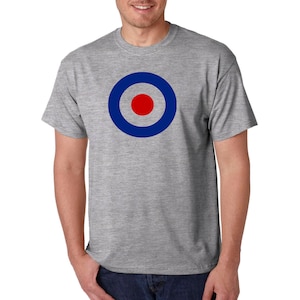 May include: A gray t-shirt with a blue and red target design. The target has a red center and three blue rings.