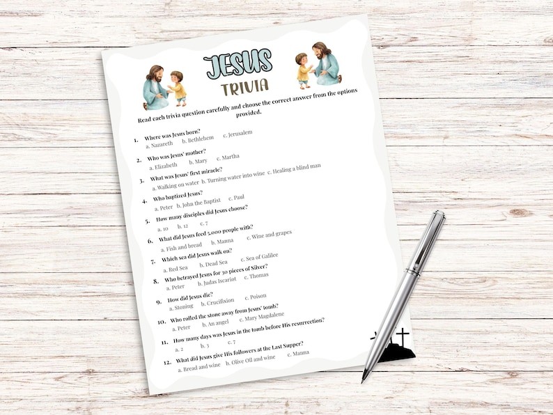 Pu&ograve; includere: Un foglio di gioco a quiz stampato intitolato "Jesus Trivia" con domande sulla vita di Ges&ugrave;. Il foglio include illustrazioni di Ges&ugrave; e di un bambino. Una penna d'argento poggia sulla superficie di legno.