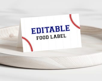 Könnte beinhalten: Ein weißes Baseball-Food-Label mit dem Wort „EDITABLE“ in Blau und den Worten „FOOD LABEL“ in Schwarz. Rote Baseball-Nähte akzentuieren die Ecken. Das Etikett wird auf einem hellen Holztablett angezeigt.