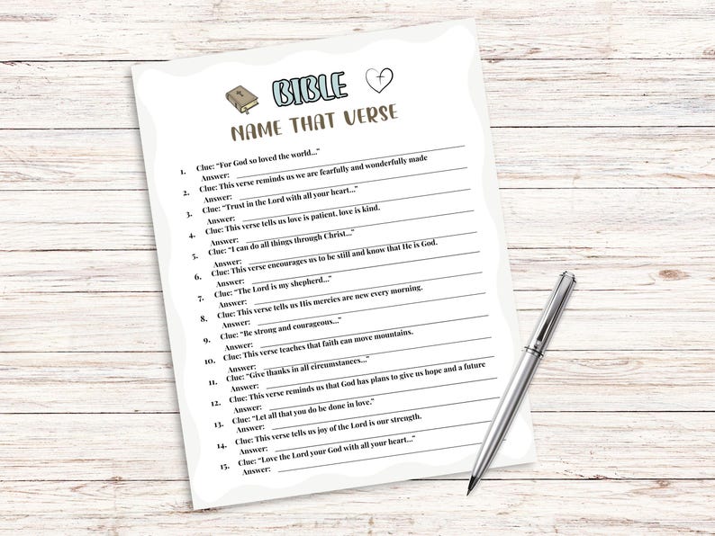 Pu&ograve; includere: Un foglio di carta bianco intitolato "BIBLE NAME THAT VERSE" con una penna su una superficie di legno chiaro. Il foglio presenta indizi di versetti biblici con spazi per le risposte. Un libro e un cuore in alto.