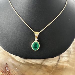 14 karat yellow gold, filled emerald pendant with chain and diamond bail.