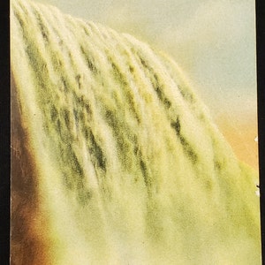 Może przedstawiać: Winietkowa pocztówka przedstawiająca zbliżenie Amerykańskich Wodospadów w Niagara Falls. Woda spada w kaskadzie w białej i zielonej mgle, z brązową skalistą podstawą u dołu.