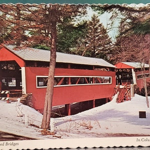 Op de afbeelding: Een ansichtkaart met een foto van twee rode overdekte bruggen in een besneeuwde winterse omgeving. De tekst op de ansichtkaart luidt "Twin Covered Bridges In Columbia County, Pa."