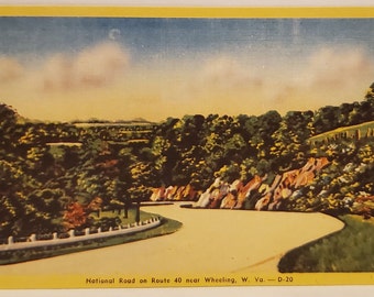 Könnte beinhalten: Vintage Postkarte mit einer malerischen Ansicht der Nationalstraße auf der Route 40 in der Nähe von Wheeling, West Virginia. Das Bild zeigt eine kurvenreiche Straße durch eine üppige, grüne Landschaft mit blauem Himmel und weißen Wolken. Die Postkarte hat einen gelben Rand.