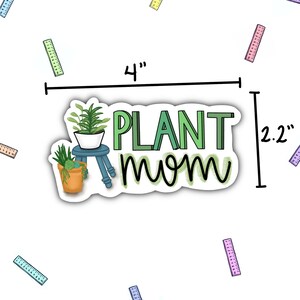 May include: A white sticker with green text that says "PLANT mom" and a green and blue illustration of a potted plant on a stool. The sticker is 4 inches wide and 2.2 inches tall.