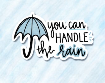 May include: A blue and white sticker with a black outline of an umbrella and the text "you can handle the rain".