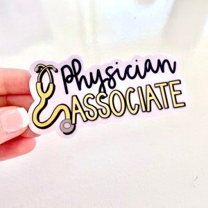 May include: A white sticker with the text "Physician Associate" in black lettering with a yellow outline. A yellow stethoscope is pictured to the left of the text.