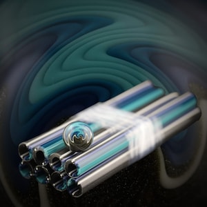 May include: A group of five clear glass tubes with a blue and silver iridescent finish. The tubes are stacked on top of each other and a small blue and silver marble is resting on top of the tubes.