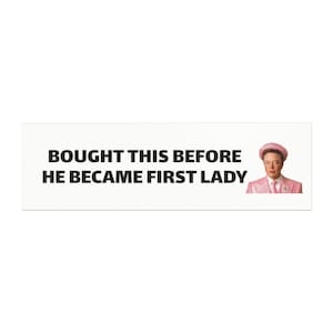 May include: A white banner with black text that reads "Bought this before he became first lady". A photo of a person wearing a pink suit and a pink hat is on the right side of the banner.
