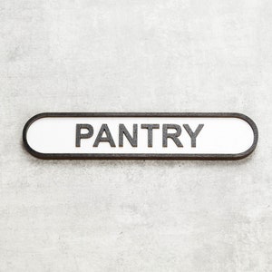 May include: A white rectangular sign with black trim and the word "PANTRY" in black lettering.