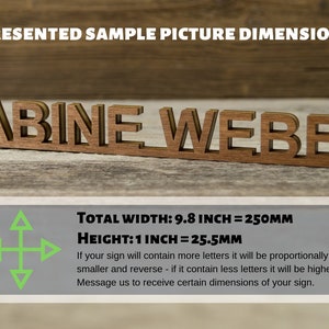 May include: A wooden sign with the name "SABINE WEBER" in a decorative font. The sign is 9.8 inches wide and 1 inch tall. The text below the sign explains that the dimensions will vary depending on the number of letters in the name.