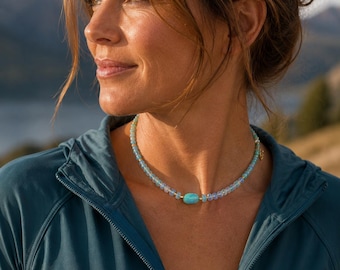 Peut inclure: Un collier de perles composé de petites perles bleu clair translucides et d'une perle centrale plus grande de forme ovale couleur turquoise. Le collier est agrémenté de petites entretoises dorées et d'un fermoir délicat de couleur dorée.